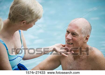 Senior couple smiling at a swimming pool View Large Photo Image Stock Image - Senior couple smiling at a swimming pool. Fotosearch