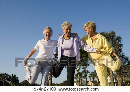 Senior women laughing while balancing on one leg View Large Photo Image Stock Image - Senior women laughing while balancing on one leg. Fotosearch