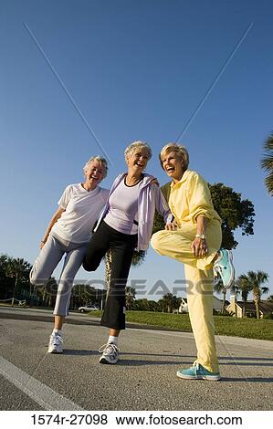 Senior women laughing while balancing on one leg View Large Photo Image Stock Photo - Senior women laughing while balancing on one leg. Fotosearch