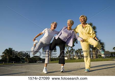 Senior women laughing while balancing on one leg View Large Photo Image Stock Photo - Senior women laughing while balancing on one leg. Fotosearch