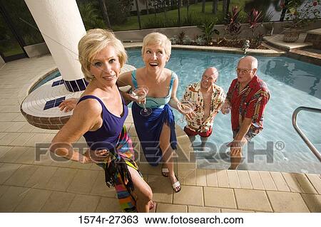 Senior women standing poolside while senior men in swimming pool View Large Photo Image Stock Image - Senior women standing poolside while senior men in swimming pool. Fotosearch