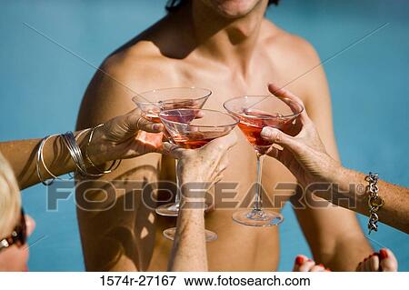 Senior women toasting drinks in front of a bare chested man View Large Photo Image Stock Photo - Senior women toasting drinks in front of a bare chested man. Fotosearch
