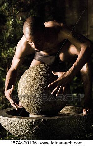 Shirtless man standing on a round structure View Large Photo Image Stock Photograph - Shirtless man standing on a round structure. Fotosearch