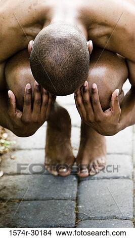 Shirtless young man sitting on the floor and hugging his knees View Large Photo Image Picture - Shirtless young man sitting on the floor and hugging his knees. Fotosearch