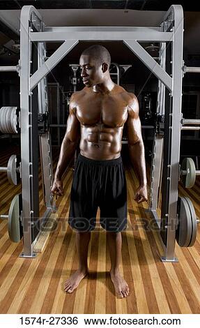 Shirtless young man standing in the gym with his clenched fist View Large Photo Image Stock Photograph - Shirtless young man standing in the gym with his clenched fist. Fotosearch