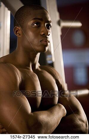 Shirtless young man standing in the gym with arms crossed View Large Photo Image Stock Photography - Shirtless young man standing in the gym with arms crossed. Fotosearch