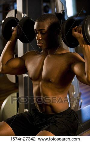 Shirtless young man working out with dumbbells in the gym View Large Photo Image Stock Image - Shirtless young man working out with dumbbells in the gym. Fotosearch