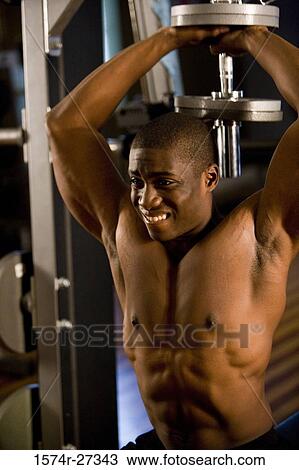 Shirtless young man working out with dumbbells in the gym View Large Photo Image Stock Image - Shirtless young man working out with dumbbells in the gym. Fotosearch