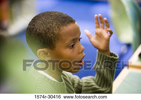 Side view of a boy gesturing View Large Photo Image Stock Photograph - Side view of a boy gesturing. Fotosearch