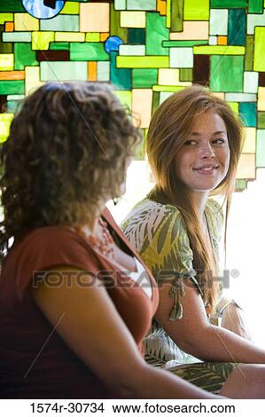 Picture - Sisters sitting together and smiling. Fotosearch