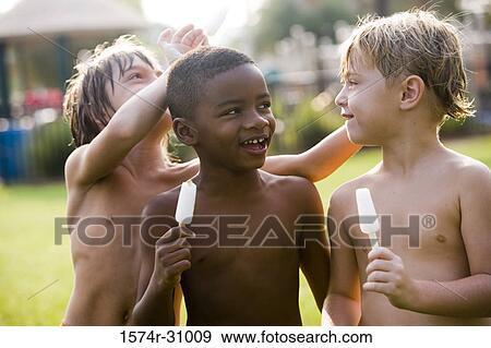 Smiling bare chested boys eating flavored ice View Large Photo Image Stock Photo - Smiling bare chested boys eating flavored ice. Fotosearch