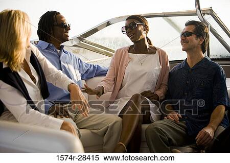 Smiling friends conversing in the boat View Large Photo Image Stock Photography - Smiling friends conversing in the boat. Fotosearch