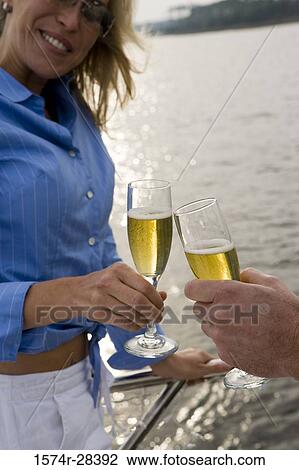 Smiling mid adult woman toasting champagne flutes View Large Photo Image Stock Image - Smiling mid adult woman toasting champagne flutes. Fotosearch