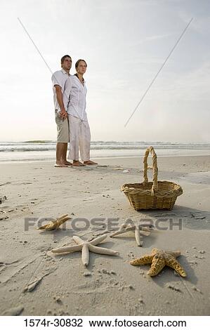 Starfishes by basket with young couple on the beach View Large Photo Image Stock Image - Starfishes by basket with young couple on the beach. Fotosearch