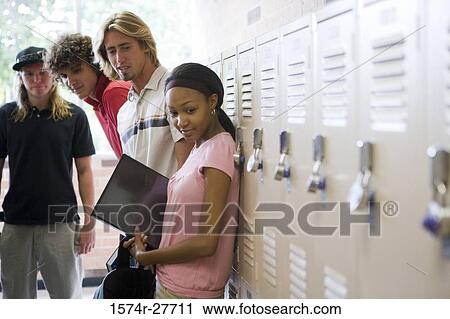 Students leaning by lockers and looking down View Large Photo Image Stock Image - Students leaning by lockers and looking down. Fotosearch