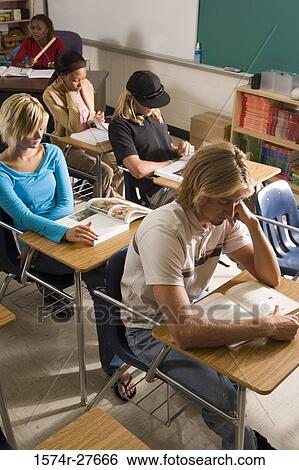 Stock Photograph - Students reading book in the classroom. Fotosearch