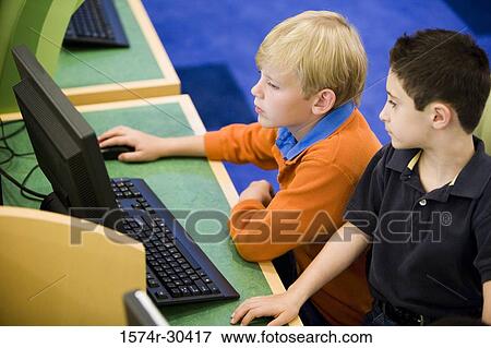 Stock Photo - Students sitting at a computer in the library. Fotosearch