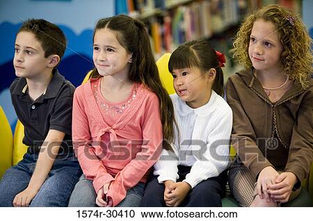 Stock Image - Students sitting side by side in the library. Fotosearch