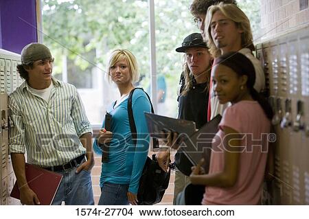 Picture - Students smiling and standing by lockers in corridor. Fotosearch