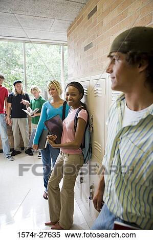 Stock Photography - Students smiling and standing by lockers in corridor. Fotosearch