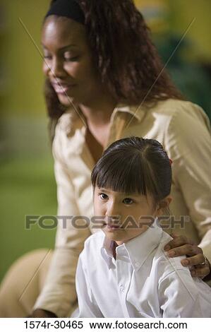 Teacher sitting with a schoolgirl View Large Photo Image Stock Photography - Teacher sitting with a schoolgirl. Fotosearch