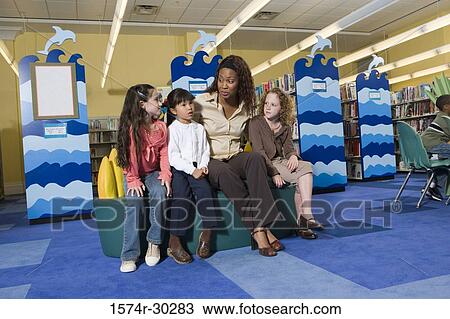Teacher sitting with schoolgirls in the library View Large Photo Image Stock Image - Teacher sitting with schoolgirls in the library. Fotosearch