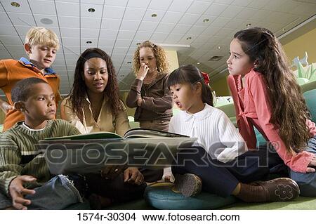 Teacher teaching students in the library View Large Photo Image Picture - Teacher teaching students in the library. Fotosearch