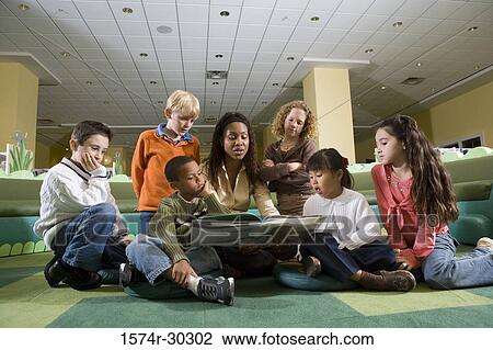 Teacher teaching students in the library View Large Photo Image Stock Image - Teacher teaching students in the library. Fotosearch