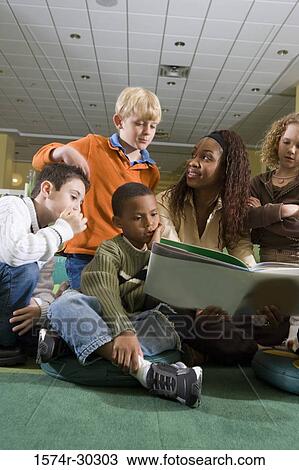 Stock Image - Teacher teaching students in the library. Fotosearch
