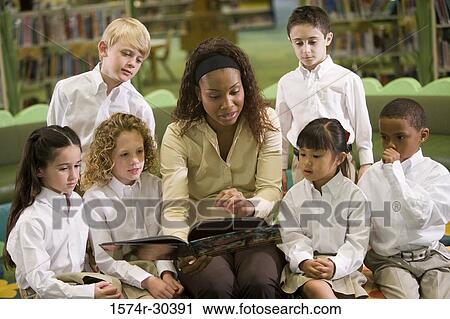 Teacher teaching students in the library View Large Photo Image Stock Image - Teacher teaching students in the library. Fotosearch