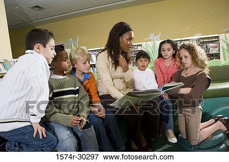 Teacher teaching students in the library View Large Photo Image Stock Photo - Teacher teaching students in the library. Fotosearch