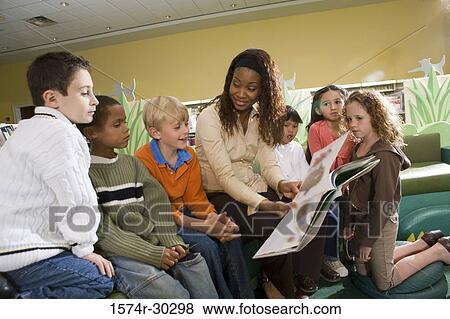 Teacher teaching students in the library View Large Photo Image Stock Photo - Teacher teaching students in the library. Fotosearch