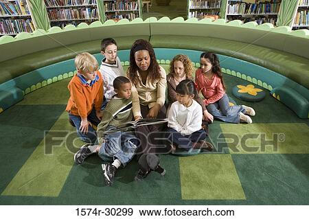 Teacher teaching students in the library View Large Photo Image Stock Photo - Teacher teaching students in the library. Fotosearch