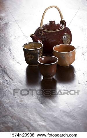 Teapot and tea cups kept on the table View Large Photo Image Stock Photo - Teapot and tea cups kept on the table. Fotosearch