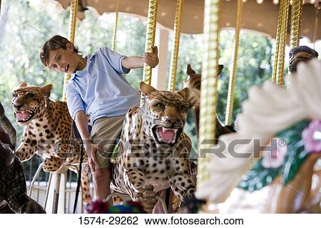 Teenage boy sitting on a carousel leopard View Large Photo Image Stock Image - Teenage boy sitting on a carousel leopard. Fotosearch