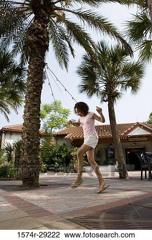 Teenage girl dancing under the palm tree with a house in the background View Large Photo Image Stock Image - Teenage girl dancing under the palm tree with a house in the background. Fotosearch