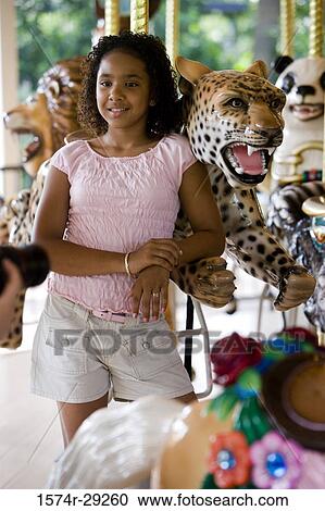 Teenage girl standing in a carousel by a carousel leopard View Large Photo Image Stock Image - Teenage girl standing in a carousel by a carousel leopard. Fotosearch