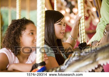 Teenage girls holding poles in a carousel View Large Photo Image Picture - Teenage girls holding poles in a carousel. Fotosearch