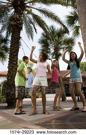 Teenagers dancing under a palm tree with a house in the background View Large Photo Image Stock Image - Teenagers dancing under a palm tree with a house in the background. Fotosearch