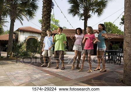 Teenagers dancing under the palm tree with a house in background View Large Photo Image Picture - Teenagers dancing under the palm tree with a house in background. Fotosearch