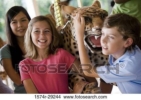 Teenagers holding a carousel leopard and smiling View Large Photo Image Picture - Teenagers holding a carousel leopard and smiling. Fotosearch