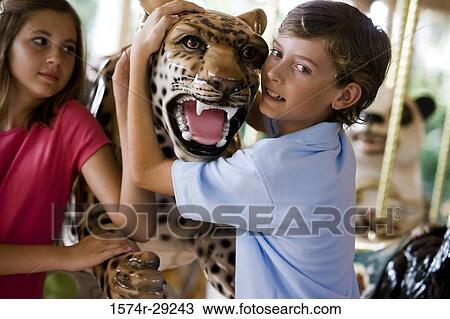Teenagers holding a carousel leopard and smiling View Large Photo Image Stock Image - Teenagers holding a carousel leopard and smiling. Fotosearch