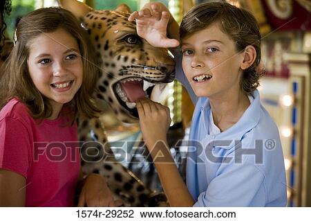 Teenagers holding a carousel leopard and smiling View Large Photo Image Stock Image - Teenagers holding a carousel leopard and smiling. Fotosearch
