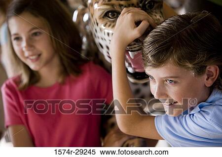 Stock Photography - Teenagers holding a carousel leopard and smiling. Fotosearch