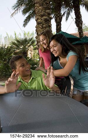 Teenagers playing by a table View Large Photo Image Picture - Teenagers playing by a table. Fotosearch
