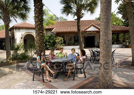 Teenagers sitting by a table and eating apples View Large Photo Image Stock Image - Teenagers sitting by a table and eating apples. Fotosearch