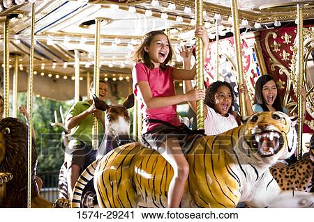 Stock Image - Teenagers sitting on a carousel and shouting. Fotosearch