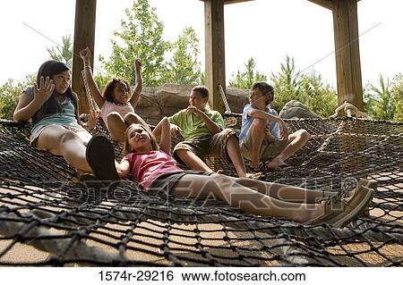 Teenagers sitting on net tied to the wooden columns View Large Photo Image Stock Photograph - Teenagers sitting on net tied to the wooden columns. Fotosearch