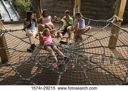 Teenagers sitting on net tied to the wooden columns View Large Photo Image Stock Photography - Teenagers sitting on net tied to the wooden columns. Fotosearch