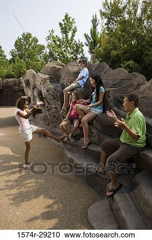 Teenagers sitting on rocks and playing View Large Photo Image Stock Image - Teenagers sitting on rocks and playing. Fotosearch